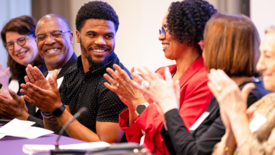 Members of the Quality of Life Symposium panel clap during the 2024 event.