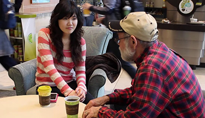 Female buddy talks to a male mentor at a coffee shop