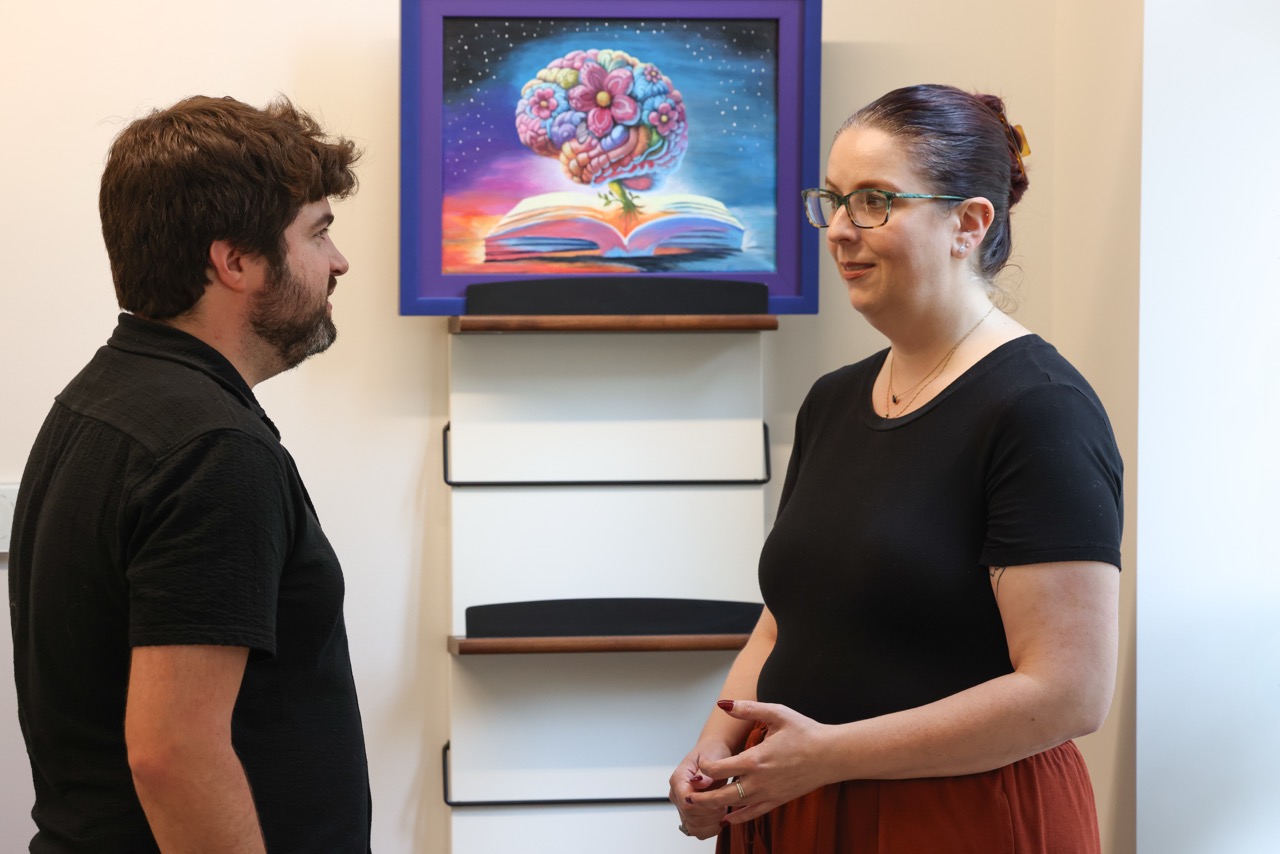 Mesulam Center staff members talk in front of painting